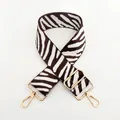 Detailed view of adjustable zebra print bag strap with polished gold-tone metal hardware - No. 53 White Coffee
