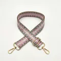 Close-up of pink and grey geometric woven shoulder strap with gold metal lobster clasps - Pink