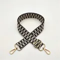 Close-up of black and white zigzag woven strap with premium gold metal hardware hooks - Brown