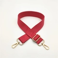Detail of red nylon shoulder strap with gold-tone hardware and adjustable buckle - Watermelon red