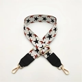 Dettaglio della tracolla regolabile intrecciata con stelle, punte in pelle e fibbie oro - Bianco + Pelle Nera