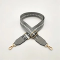 Macro detail of grey chevron woven shoulder strap with gold metal buckle and swivel hooks - Gray