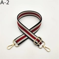 Detail showing adjustable red, cream, and black striped bag strap with gold metal hardware - Black Burgundy Striped (A-2)