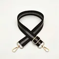 Close-up of No. 9 black and grey striped adjustable fabric bag strap with gold metal buckles - No. 9 Coffee Silver Stripe
