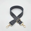 Close-up of adjustable black and white geometric wave strap with gold metal hardware - Black