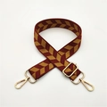 Detail eines verstellbaren gewebten Schultergurts mit Chevron-Muster und goldenen Metallhaken - Burgunderrot