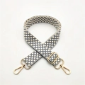 Close-up of adjustable woven shoulder strap with grey-blue pattern and gold metal hardware - Gray
