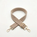 Close-up of thick woven brown polka dot bag strap with gold metal lobster clasps - Brown