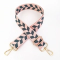 Close-up of pink woven guitar strap with green herringbone pattern and gold metal hooks - Pink