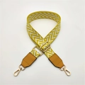 Detail of woven diamond pattern bag strap with brown leather and gold metal buckle - Yellow