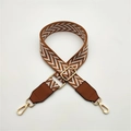 Detail of adjustable PU leather bag strap featuring brown chevron weaving and gold hardware - Brown