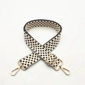 Close-up of woven bag strap with star pattern and adjustable gold metal lobster clasps - Brown