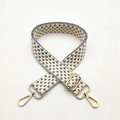 Close-up of adjustable gray and white woven shoulder strap with gold metal lobster clasps - Gray