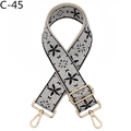 Close-up of wide embroidered bag strap with grey floral pattern and gold metal buckles - C-45 Black Gray Floral