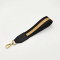 Detailansicht der gestreiften Handschlaufe mit schwarzem Leder und goldener Karabiner - Silberverschluss / Schwarz Gold + Schwarzes Leder