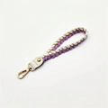 Close-up of woven wrist strap with purple and gold rope textures and metallic gold clasp - Purple