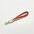 Detail view of woven orange and beige strap with gold metal lobster clasp and leather joint - Orange