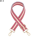 Detail eines verstellbaren bunten Streifengurts mit goldenen Karabinerhaken und Schnallen - Silberverschluss / M-4 Rosa