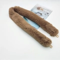 Detailed view of fluffy brown faux fur bag strap with gold metal lobster clasps on white base - Camel