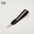 Detail of woven wrist strap with glitter stripes and golden metal lobster clasp - Black Gold Silver Stripe