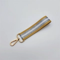 Detail of ginger and silver striped woven wrist strap with golden lobster clasp for bags - Silver Clasp / Yellow