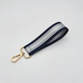 Detail of navy and silver striped woven wristlet strap with a gold lobster clasp - Blue