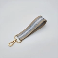Detail showing beige fabric wrist strap with silver glitter stripes and gold metal clasp - Silver Clasp / Beige
