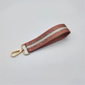 Close-up of pink woven wrist strap with silver glitter stripe and gold lobster clasp - Silver Clasp / Lotus root pink