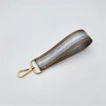 Detail of silver glitter and brown fabric strap with a golden lobster clasp accessory - Dark Khaki
