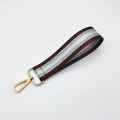 Detail of coffee woven wrist strap with silver glitter and gold lobster clasp - Brown