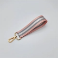 Detailed close-up of pink and grey striped woven wristlet strap with gold metal lobster clasp - Light Pink