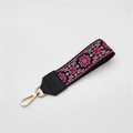 Detailed view of ethnic embroidery handbag wrist strap with floral patterns and gold clasp - Silver Clasp / Rose Red Floral On Black