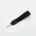 Detail der schwarzen Handschlaufe aus gewebtem Nylon mit Lederstück und goldenem Karabiner - Silberverschluss / Einfarbig Schwarz