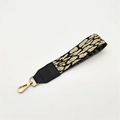 Close-up of leopard pattern woven wrist strap with gold spring buckle and leather connector - Khaki Leopard