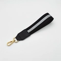 Close-up of black and grey striped braided wrist strap with gold swivel lobster clasp - Black Silver Striped