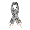 Close-up of woven bag strap with black and white diamond pattern and gold metal hooks - Black