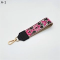Dettaglio della tracolla ricamata con fiori etnici e moschettone in metallo dorato - Ipomoea Rosa Con Pelle Sintetica Nera (A-1) / Chiusura in Argento