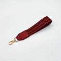 Close-up of woven bag strap with red and black geometric patterns and gold metal clasp - Burgundy