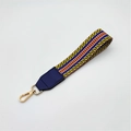 Close-up of colorful woven handbag strap with blue leather ends and golden metal clasp - Silver Clasp / Yellow Blue Stripe + Blue Leather