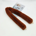 Detail of dark brown faux fur bag strap with gold metal hooks on white surface - Brown