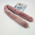 Macro shot of dusty pink faux rabbit fur shoulder strap with golden metal hooks - Pink