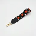 Detail of black woven wrist strap with orange and white stars and golden lobster clasp - No.6 Black Orange Star