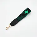 Detail view of leopard print handbag wrist strap with gold metal lobster clasp and leather trim - No.13 Green Black Star