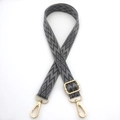 Macro view of adjustable woven bag strap with grey geometric patterns and gold lobster clasps - Dark Gray