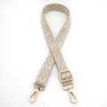 Detail of adjustable woven bag strap featuring gold metal lobster clasps and geometric patterns - Khaki