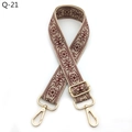 Close-up of ethnic woven bag strap with red-brown patterns and golden metal swivel hooks - Beige and Wine Red