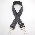 Macro shot of adjustable woven bag strap with geometric texture and gold metal hooks - Silver Clasp / Black and Gray (No. 6) / [product Attributes] This Product Is A Replacement Shoulder Strap For A Bag. Visually It Appears To Be Made Of Thickened Nylon Or Polyester Woven Material With A Black And Gray Geometric Textured Surface. The Shoulder Strap Has Light Gold Zinc Alloy Rotating Hooks At Both Ends And A Metal Adjustment Buckle Making It An Adjustable-length Wide Shoulder Strap. [visual Presentation] The Image Uses A Flat Product Layout With A Pure White Background. Image Quality Is [high] Clear And Sharp With Even Light And Shadow Distribution. Aesthetics Are [medium] Overall Score [7.2]. The Display Style Is Typical Of Factory Sample Photos Lacking A Sense Of Atmosphere And Brand Identity. [text Content] The Upper Left Corner Contains The Chinese Characters "6号" Which Is An Internal B2b Number. It Has No Practical Value For Cross-border Buyers And Disrupts The Visual Appeal; It Is Recommended To Remove It Using `to_remove`. [logistics Tags] None [infringement Risk] Product Infringement: None As It Is A General Accessory Design; Background Infringement: None. [product Parameters] Woven Texture Structure Light Gold Metal Hardware And Adjustable-length Sliding Buckle Were Identified.