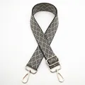 Detail of adjustable black and white woven bag strap with light gold metal lobster clasps - Silver Clasp / Black and Beige (No. 19) / 【product Attributes】this Product Is A 【wide Woven Bag Replacement Shoulder Strap】. The Material Appears To Be Thickened Canvas Or A Cotton Blend Featuring A Black And White Alternating Geometric Twill/herringbone Pattern Giving It A Retro Yet Modern Visual Style. Accessories Are Made Of 【light Gold Metal Hardware】 Including Two 360-degree Rotating Lobster Buckles And A Metal Adjustable Buckle Allowing For Length Adjustment As Needed. 【visual Presentation】the Image Uses A Classic 【plain White Background Flat Lay Shot】 With A Symmetrical Centered Composition Showcasing The Complete Shape Of The Shoulder Strap And Hardware Details. Image Quality Is 【high】 With Accurate Focus And Even Lighting. Aesthetics Are 【medium】 Overall Score Is 【7.0】 The Main Issue Being The Somewhat Bland Presentation And Lack Of Emotional Appeal. 【text Content】the "to_remove" Group Contains The "19" Text In The Upper Left Corner Which Is A Later Sku Label Added By The Seller And Needs To Be Removed. The Remaining Groups Are Empty. 【logistics Tags】none 【infringement Risk】product Infringement: None Appears To Be A Generic Woven Style. Infringement Probability [0.1]. Background Infringement: None. 【product Parameters】color: Black And Beige Color Combination; Hardware: Light Gold; Craftsmanship: Jacquard Weaving.