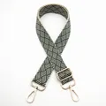 Close-up of woven bag strap in dark green and beige with gold metal lobster clasps - Silver Clasp / Green (No. 26) / [product Attributes] This Appears To Be A Widened Woven Bag Strap. The Color Scheme Features An Alternating Geometric Pattern Of Dark Green And Beige. It Is Equipped With A Gold-plated Metal Adjustment Buckle And A Lobster Hook. The Strap Has A Distinct Woven Texture. [visual Presentation] The Image Uses A Pure White Background With A Flat Layout. The Image Quality Is High With Even Lighting And Clear Details. Aesthetics Are Moderate With An Overall Score Of 7.8. The Overall Performance Is Average; The Display Is Clear But Lacks A Compelling Context. [text Content] The `to_remove` Option In `text_groups` Contains The Chinese Internal Number "26" In The Upper Left Corner Which Needs To Be Removed. [logistics Labels] None. [infringement Risk] The Product Itself Has No Obvious Brand Markings Therefore It Is Considered [none]. The Probability Of Infringement Is 0.0%. [product Parameters] No Specific Specifications Are Indicated In The Image Except For The Number.
