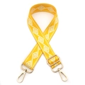 Detail of adjustable yellow nylon bag strap with white geometric patterns and gold clips - Yellow